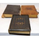 Three antique photograph albums containing a good quantity of photographs and postcards