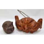 An oriental pottery pigs head together with a carved wood head rattle (2).