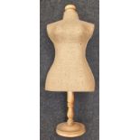 A vintage dressmakers dummy on wooden stand.