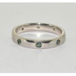 A 925 silver band ring set with peridots Size O.