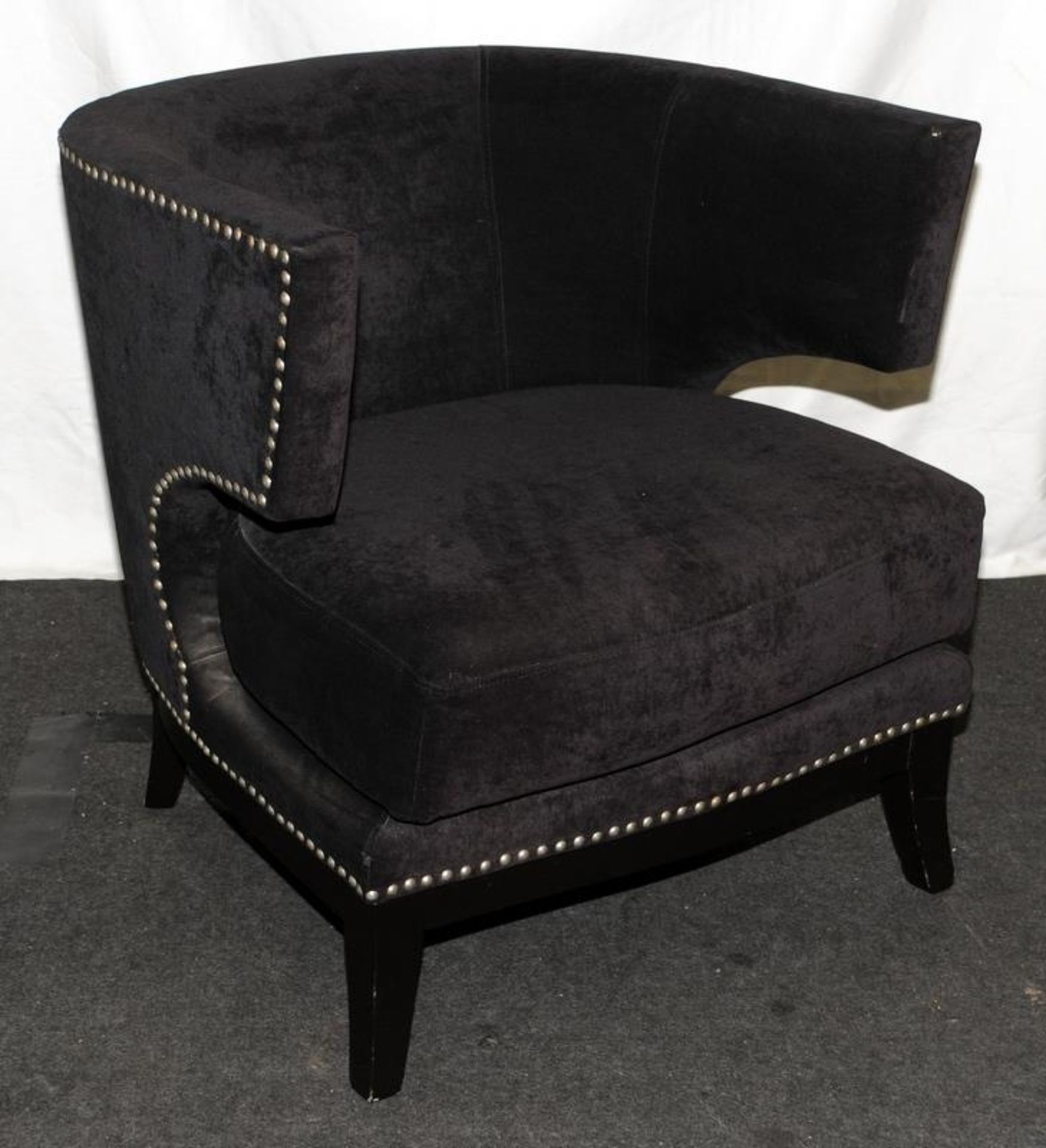 Contemporary tub chair upholstered in black fabric with stud detailing. Seat height 42cms, 76cms