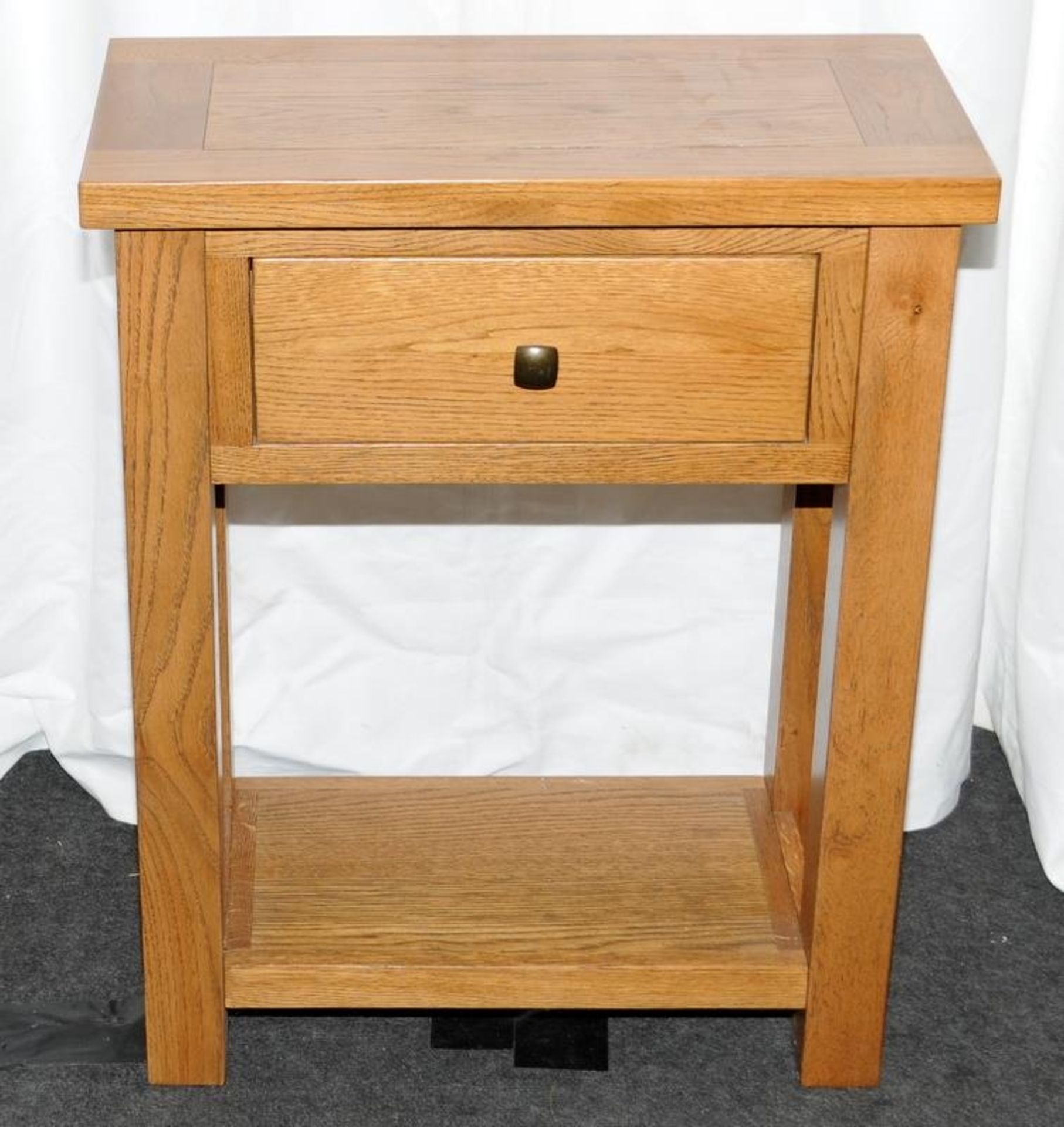 Solid oak side table with single drawer over low shelf. 75cms high x 60cms wide x 30cms deep