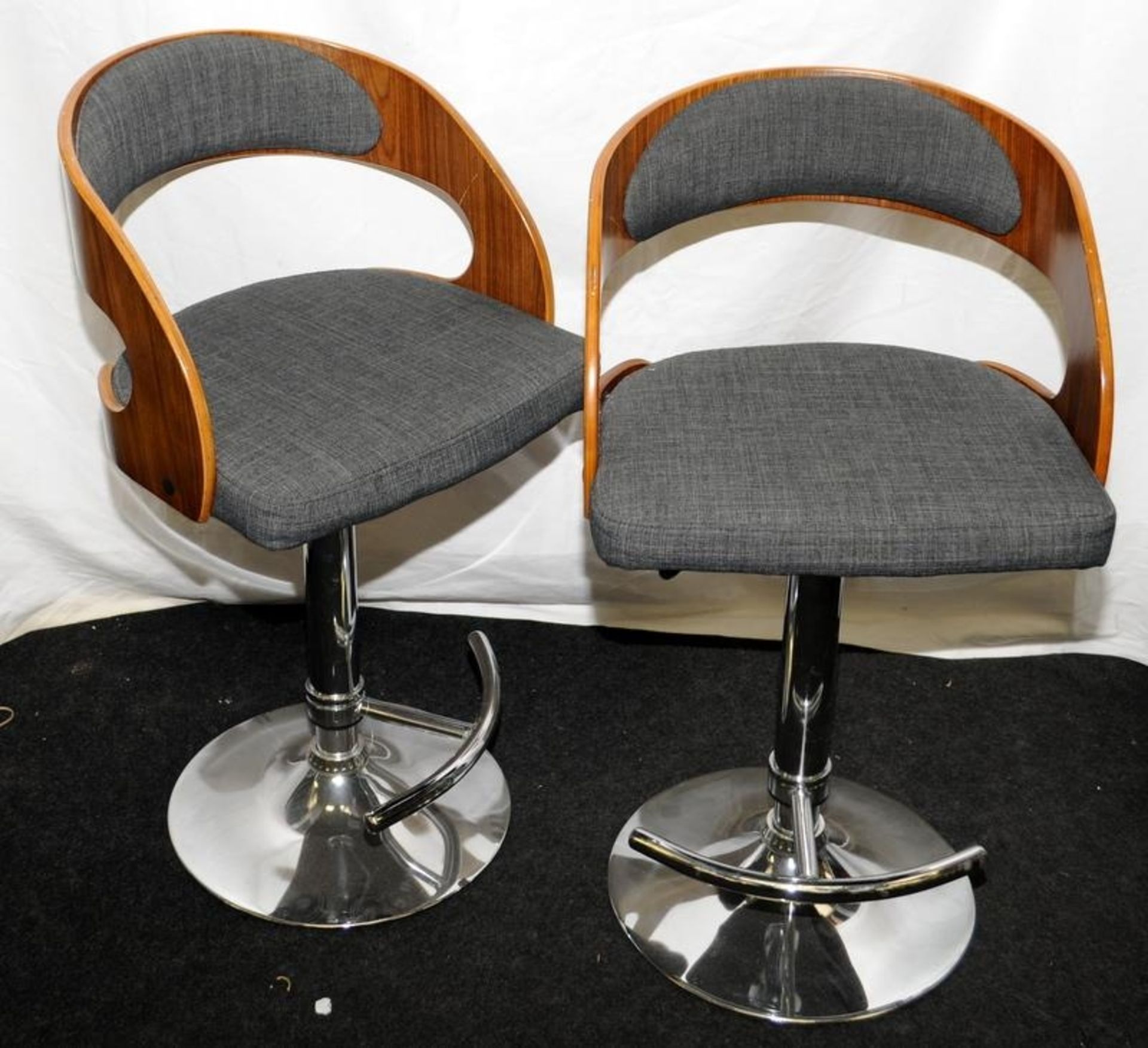 Pair of height adjustable bar stools in chrome and teak with grey upholstery.