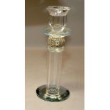 A cut glass candle holder with mirrored base and faceted and jewelled column. 21cms tall. (56)AUG