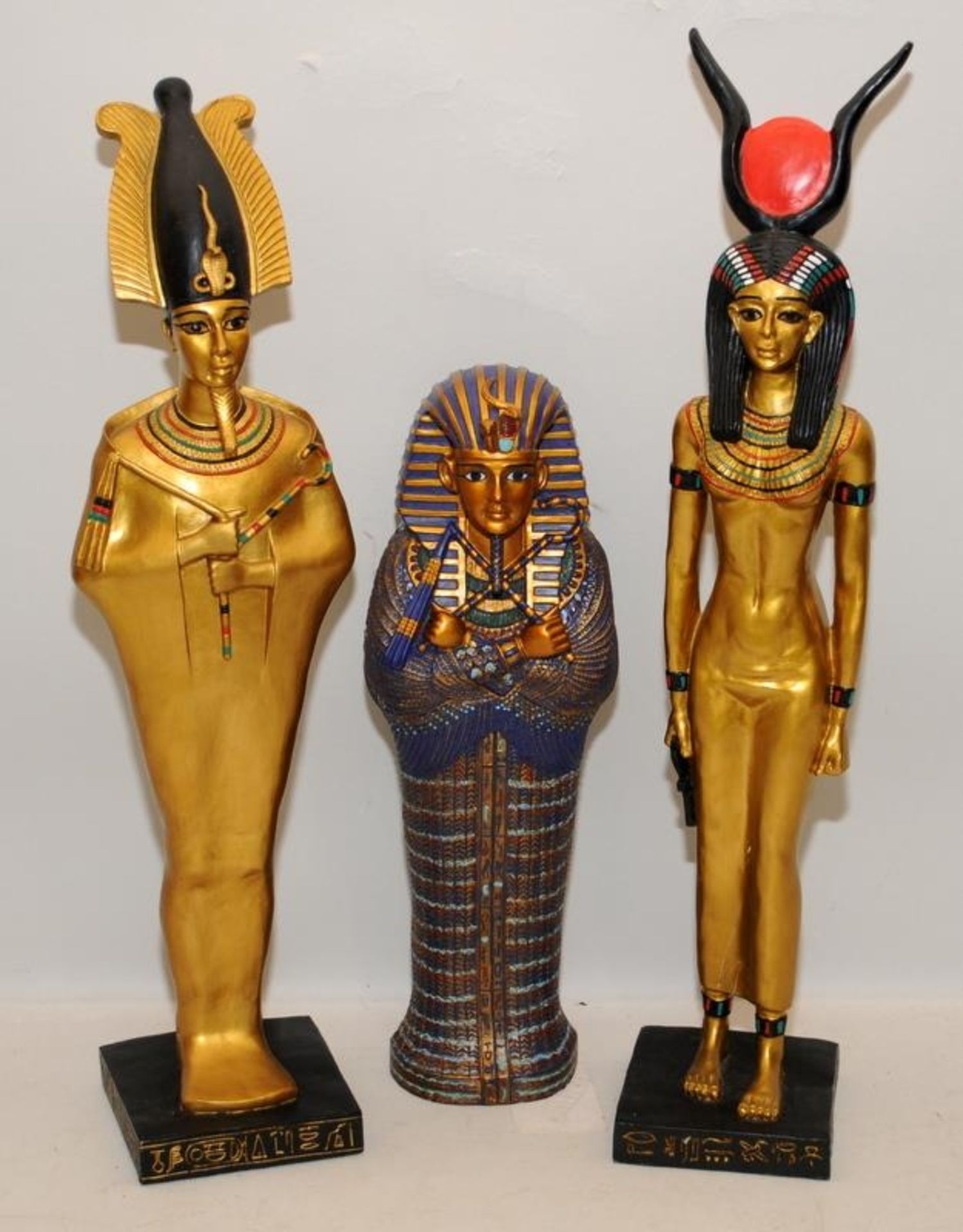 Ceramic Egyptian male and female Pharaoh figures c/w a sarcophagus. Largest figure is 43cms tall