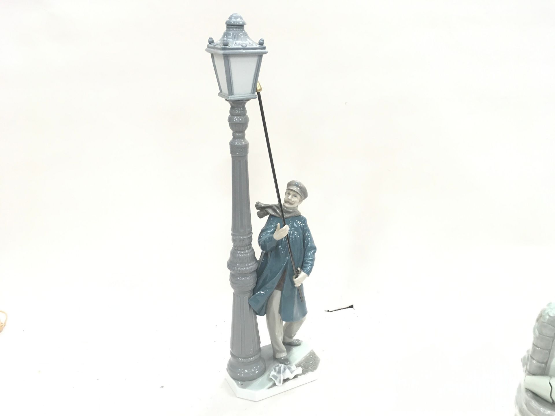 A Lladro lamp lighter figure.