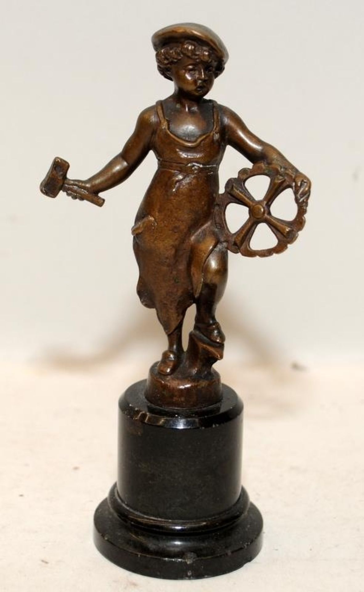 In the manner of Victor Seifert: Small bronze on stepped pedestal of a young girl blacksmith.