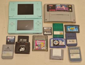 Nintendo DS Lite console together with a collection of game cartridges and memory cards.