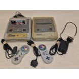 Nintendo vintage SNES console together with a Super Famicom console, two controllers, a game