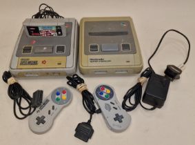 Nintendo vintage SNES console together with a Super Famicom console, two controllers, a game