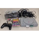 Sony PlayStation console together with a selection of boxed games, leads and accessories.