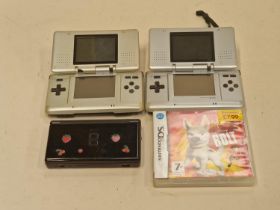 Two Nintendo DS consoles with a DS lite console and a boxed game cartridge.