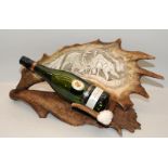Antler with carved decorative scene fashioned as a bottle holder