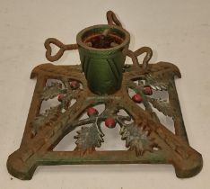 Vintage cast metal Christmas tree stand depicting holly leaves and berries.