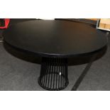 Large circular dining table with solid ebonised to supported by black powdercoated metal carousel
