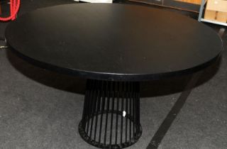 Large circular dining table with solid ebonised to supported by black powdercoated metal carousel