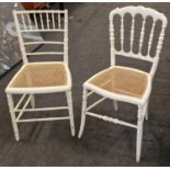 Two vintage white painted pine kitchen chairs with cane seats.