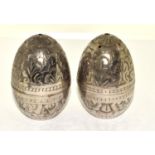 A PAIR OF INDIAN WHITE METAL 'EGG' SALT & PEPPER SHAKERS. ENGRAVED IN A FOLIATE DESIGN. HEIGHT - 6CM