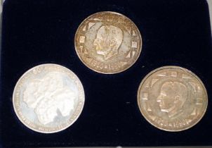Set of three commemorative silver coins in a presentation case.