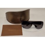 A pair of ladies designer sunglasses with case and cleaning cloth.