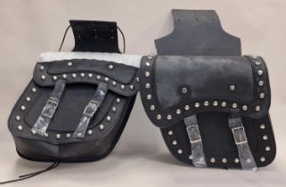 A pair of new motorcycle panniers with decorative studwork.