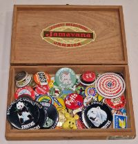 Wooden cigar box containing a collection of vintage pin and enamel badges.