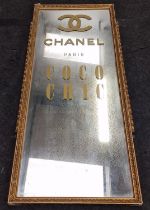 Large gilt framed mirror with applied advertising decoration 127x53cm.