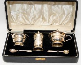 A sterling silver condiment set presented in original case. Pepperette, mustard and salt with blue
