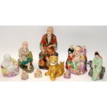 A collection of nine Chinese ceramic figures to include tradesman, buddhas, gilt foo lion and hooded