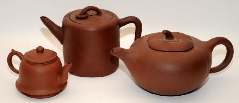 Three Chinese oriental Yixing pottery brown teapots, two of the having marks to the undersides.