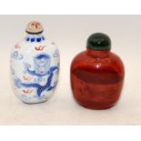 Chinese red Realgar-style snuff bottle with a green hard stone stopper together with another