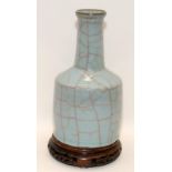 A heavily potted Oriental type crackle glazed blue mallet vase with wood stand, H27cm (signs of wear