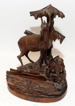 A vintage carved Black Forest inkwell and letter holder modelled as a stag in a forest setting.