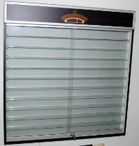 Fitted illuminated wall display cabinet having 10 glass display shelves with sliding doors and