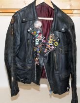 Vintage leather motorbike jacket with a collection of metal badges to include gollies. pit to pit