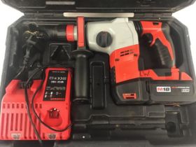 Milwaukee hammer drill with charger and battery in carry case.