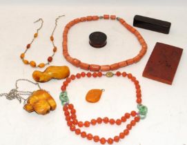 A collection of Chinese amber to include bracelet, pendant, two wood cased items and an amber plaque