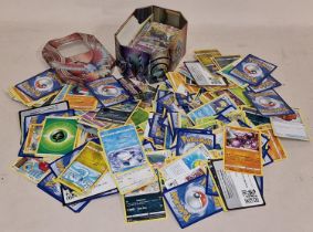 Collection of various loose Pokemon cards and collectors tin.