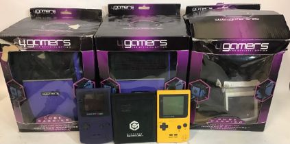 2 x Gameboy handheld devices with various cables along with 2 new boxed 4Gamers Cube Carriers.