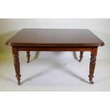 A Victorian mahogany wind-out dining table, moulded edge top and two extra leaves, raised on