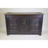 An C18th continental bog oak dresser/buffet with three cupboards and fielded carved panels with
