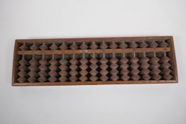 A Chinese hardwood abacus with carved characters and inscription verso, 33 x 10cm
