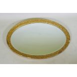 A gilt composition oval wall mirror, 59 x 86cm