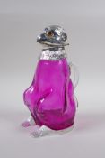 A silver plate and cranberry glass claret jug in the form of a monkey, 20cm high