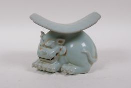 A Chinese ru ware style porcelain pillow, the base in the form of a temple lion, 11cm high