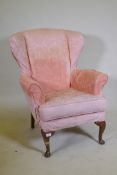 A wing back armchair, raised on cabriole supports