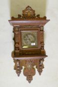 A C19th German carved oak wall clock, with brass and silvered dial and brass mounts, the spring