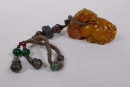 A Chinese reconstituted amber soapstone toggle in the form of a horse, 8cm long