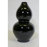 A double gourd shaped black glazed ceramic vase, initialled P.P. to base, and drilled, 41cm high