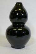 A double gourd shaped black glazed ceramic vase, initialled P.P. to base, and drilled, 41cm high